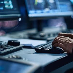 An operator's hands using a KVM system to control a video wall